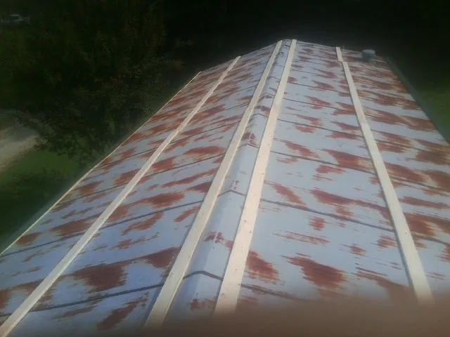 Rusted metal roof panels with new wood purlins before replacement — Storm Damage Roof Repair in Gillett by Roofing Brothers