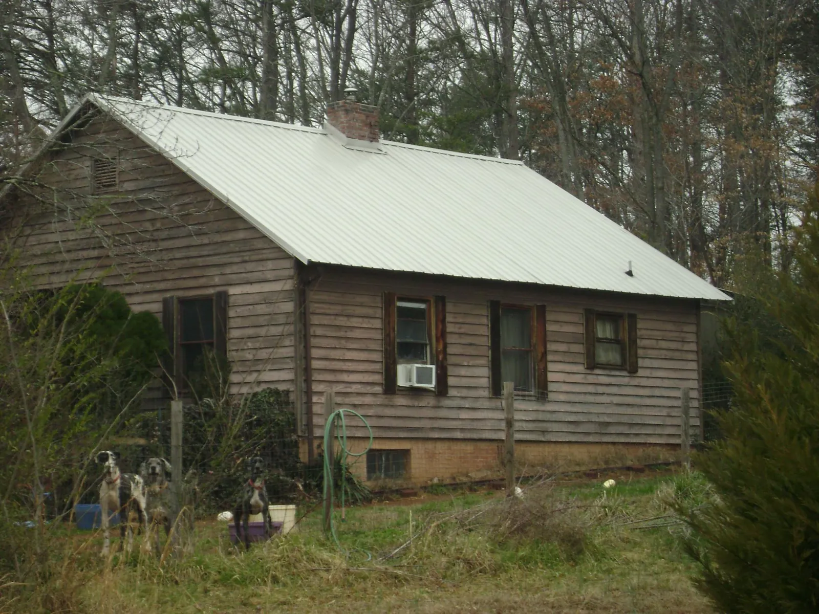 White metal roof on an old wood sided farmhouse, from a Metal Roof Installation job in Gillett